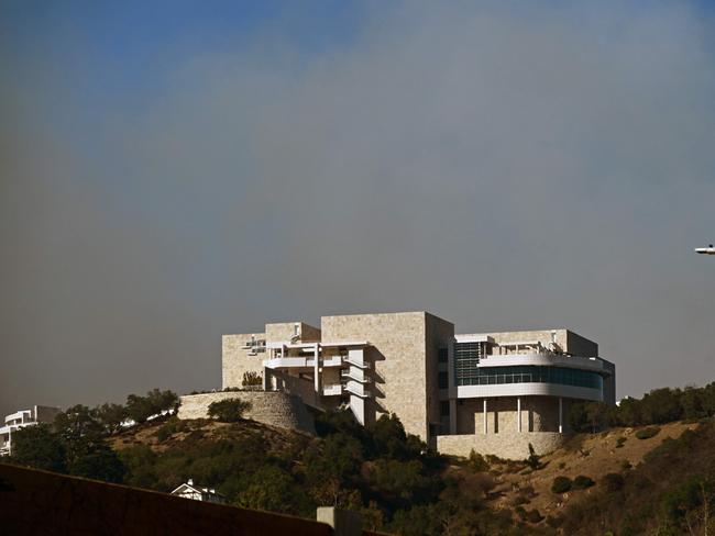 Smoke from the Palisades Fire rises over the Getty Museum in Los Angeles, California on January 11, 2025. The Palisades Fire, the largest of the Los Angeles fires, spread toward previously untouched neighborhoods January 11, forcing new evacuations and dimming hopes that the disaster was coming under control. Across the city, at least 11 people have died as multiple fires have ripped through residential areas since January 7, razing thousands of homes in destruction that US President Joe Biden likened to a "war scene." News of the growing toll, announced late Thursday January 9 by the Los Angeles County Medical Examiner, came as swaths of the United States' second-largest city lay in ruins. (Photo by Agustin PAULLIER / AFP)