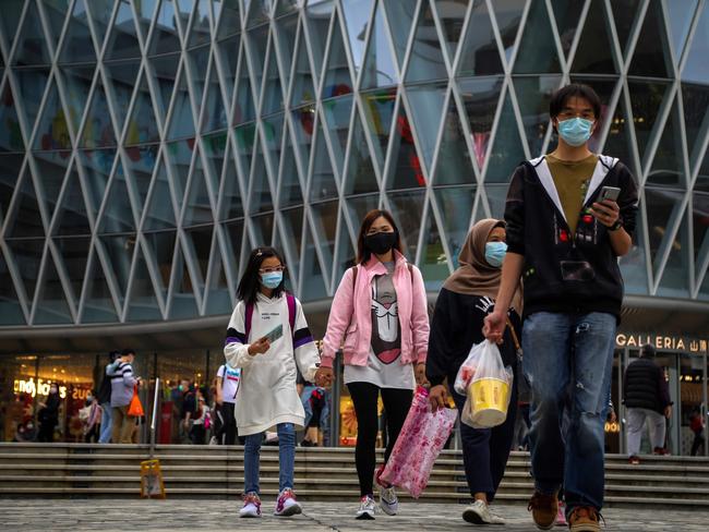 People wearing a face masks amid concerns about the spread of the COVID-19 novel coronavirus walk down a street in Hong Kong. Picture: AFP