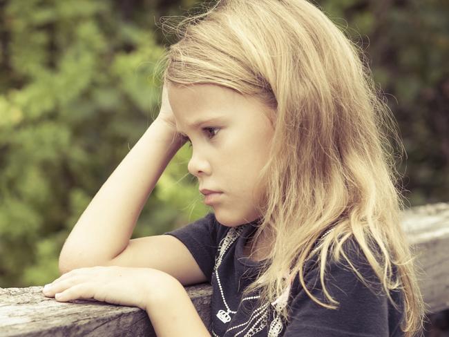 Portrait of sad blond little girl sitting on the bridge at the day timePortrait of sad blond teen girl sitting on the bridge at the day time. iStock pic