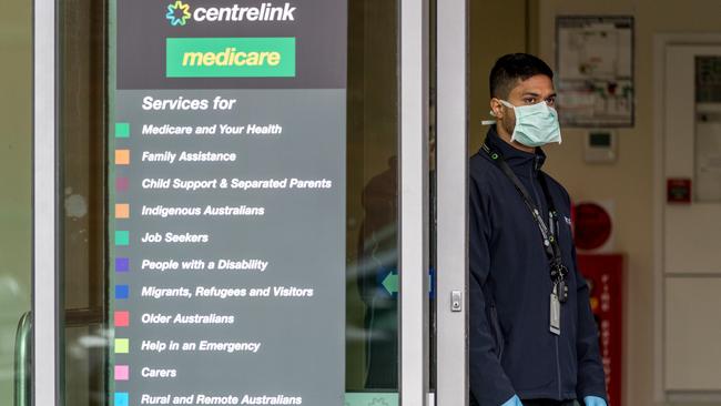 A masked Centrelink worker at Abbotsford. Picture: Jake Nowakowski