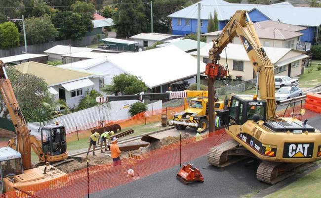 An excavator rams steel sheet piling into the site of the Yamba St landslip. Picture: Rodney Stevens