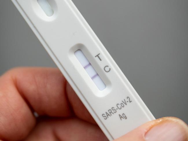 A used rapid antigen test, also known as a lateral flow test showing a positive test result for the Covid-19 coronavirus is photographed in Berlin on January 22, 2022. - Taking a test involves doing swab from inside your nostril or in your throat, depending on the test you are using, before mixing the swab with solution and dripping it onto a container with a test strip with antibodies specific to the Covid-19 virus painted on it in a thin line. If the testing strip detects the virus, it shows up as a red line next to the âTâ on the container, the line next to the âCâshould always be visible. (Photo by Odd ANDERSEN / AFP)