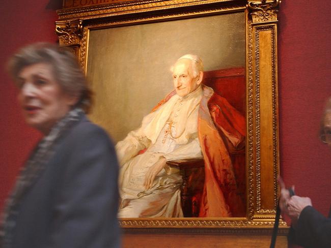 A woman passes a painting of Pope Leo XIII painted in 1900 by Hungarian artist Philip Alexius de Laszlo during an exhibition at Christie's auction house in London.