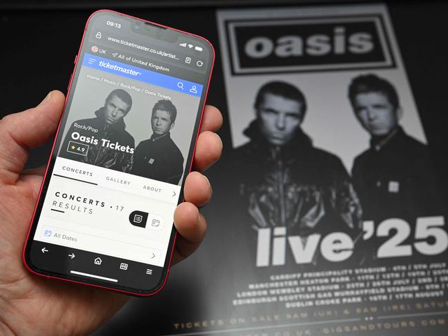 A fan uses a smart phone to access an on-line ticket sales website to purchase tickets for Oasis' "Live '25" tour taking place in 2025, at home in Marsden, northern England on August 31, 2024. Millions of Oasis fans queued online early Saturday to buy tickets for the British legends' eagerly-awaited reunion tour next year, but many were frustrated after booking websites appeared overwhelmed. (Photo by Oli SCARFF / AFP)