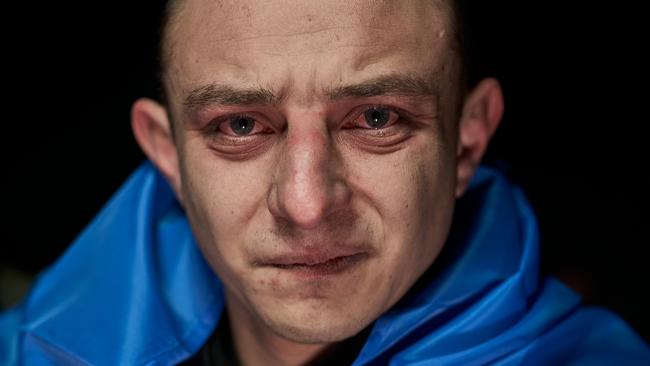 A Ukrainian, wrapped in the national flag, weeps after being freed during a prisoner exchange. Picture: Getty Images