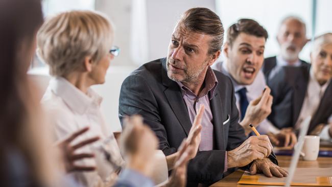 Frustrated businessman arguing with his colleagues during a business meeting in the office.