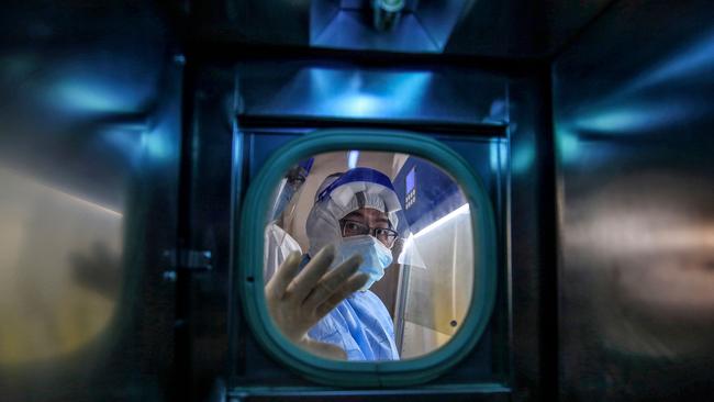 A medical professional gestures inside an isolation ward at the Red Cross Hospital in Wuhan during the height of the Covid-19 outbreak in China last year. Picture: AFP