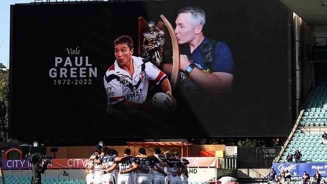 Cowboys players observe a minute’s silence following the passing of former coach Paul Green before their match against the Sydney Roosters.