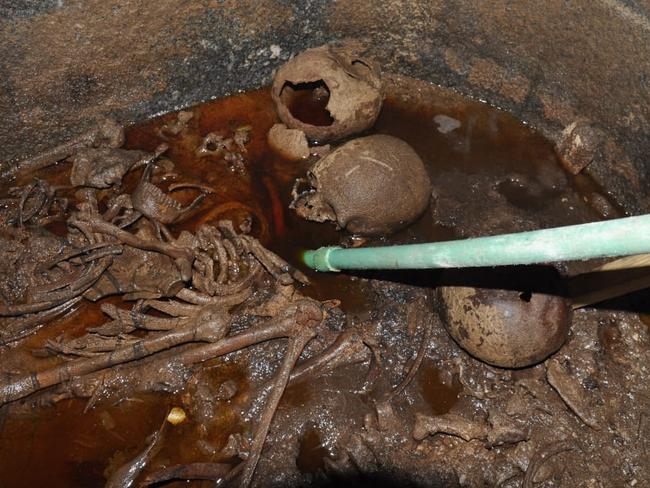 A handout picture released on July 19, 2018 by the Egyptian Antiques ministry shows skeletons in the black granite sarcophagus uncovered early this month in the Sidi Gaber district of Alexandria, filled with sewage water.