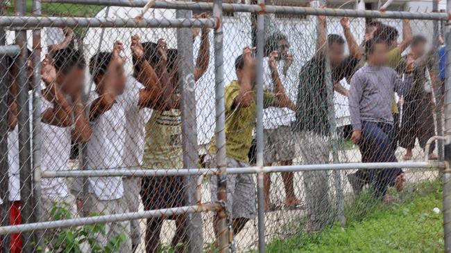 A March 21, 2014 image of asylum seekers behind a fence at the Oscar compound in the Manus Island detention centre, Papua New Guinea. Picture: AAP / Eoin Blackwell.