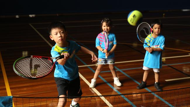 Youngsters Jerry, Jemimha and Ian take part in the ANZ Tennis Hot Shots program in Box Hill. Picture: Stuart Milligan