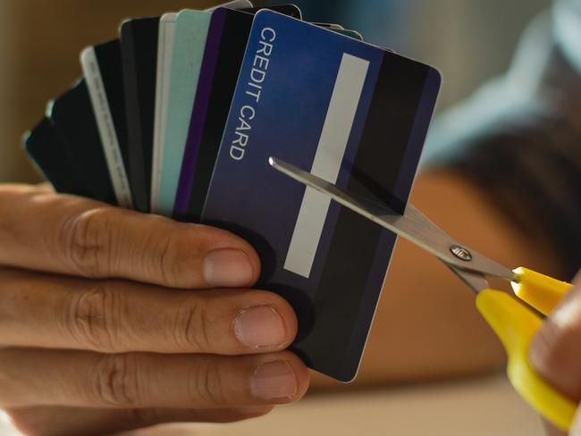 Young man cutting credit card with scissors,Man is destroying credit cards because of big debt.