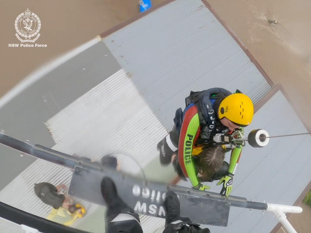 Ashley Cowan, 12, is rescued from a shed roof at Glenthorpe, near Taree, by the NSW Police helicopter crew.