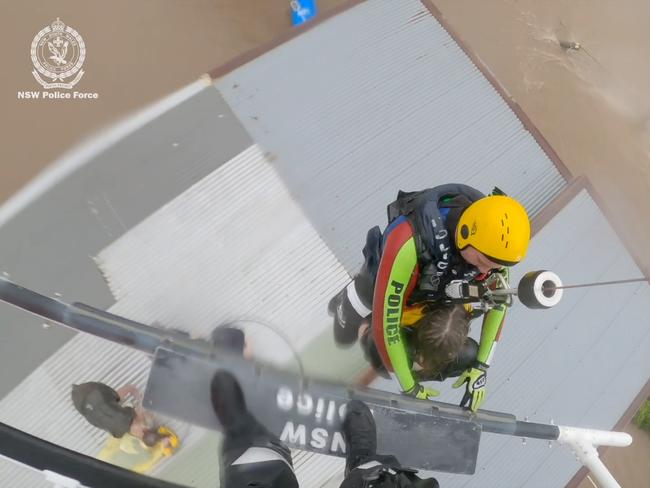 Ashley Cowan, 12, is rescued from a shed roof at Glenthorpe, near Taree, by the NSW Police helicopter crew.