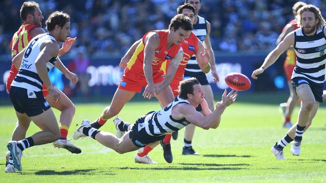 Patrick Dangerfield gets a handball away under pressure.