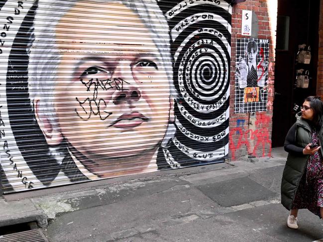 A tourist looks at a mural of Wikileaks founder Julian Assange in Melbourne on June 25, 2024.