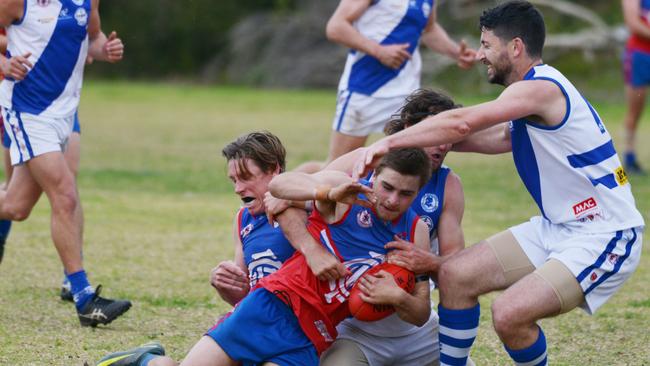 Cove’s Leighton Klomp is tackle by Port Noarlunga players during the teams’ battle on Saturday. Picture: AAP/Brenton Edwards