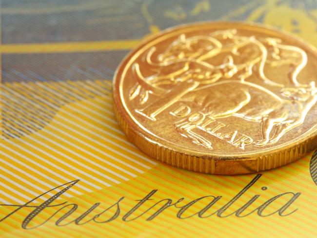 Australian one dollar coin on a fifty dollar note.  Close-up view, with shallow depth of field; generic money