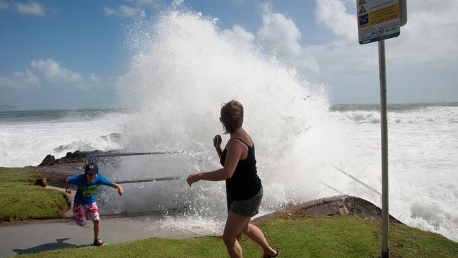 Christmas Day on the Sunshine Coast. 5 year old Jack Mercer-Barney and his mum Nicky, on holiday from Nottingham, run from the waves at Mooloolaba.