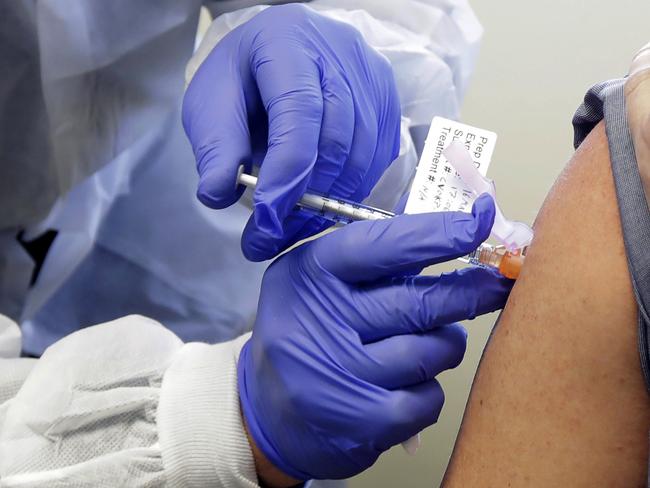 FILE - In this March 16, 2020, file photo, a patient receives a shot in the first-stage safety study clinical trial of a potential vaccine for COVID-19, the disease caused by the new coronavirus, at the Kaiser Permanente Washington Health Research Institute in Seattle. A coronavirus vaccine is still months or years away, but groups that peddle misinformation about immunizations are already taking aim -- and potentially eroding -- confidence in what could be humanityâ€™s best chance to defeat the virus. (AP Photo/Ted S. Warren, File)