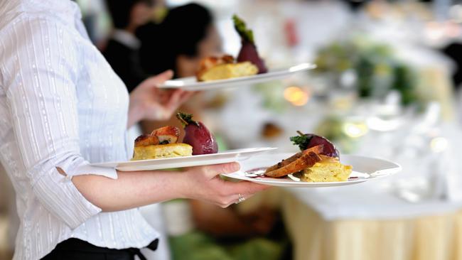 Waitress carrying three plates with meat dishGeneric photo of woman working in hospitality industry