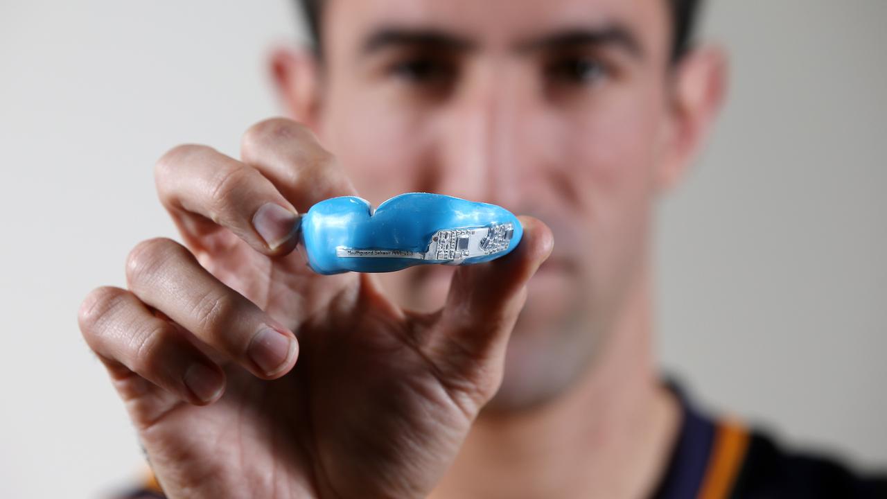 Ex-North Melbourne player Michael Firrito with a microchipped mouthguard in 2017. Picture: Michael Klein