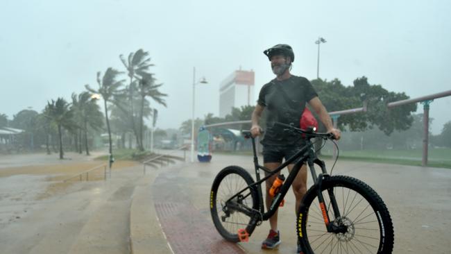 Heavy rain lashes Townsville causing flash flooding. Mick Palmer doesn't let the rain stop him going for a ride. Picture: Evan Morgan