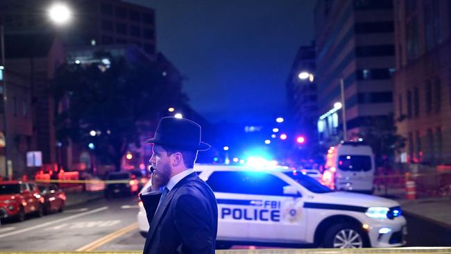 A man, standing behind police tape, talks on his cell phone outside the Capital Jewish Museum following a shooting that left two people dead, in Washington DC, on May 21, 2025. Picture: AFP