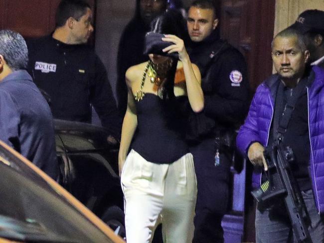 Kendall Jenner leaves the apartment under police guard. Picture: Raxel/Splash News