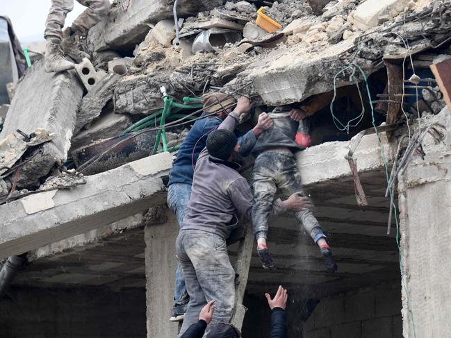 Residents retrieve an injured girl from the rubble of a collapsed building following an earthquake in the town of Jandaris, in the countryside of Syria's northwestern city of Afrin. Picture: AFP