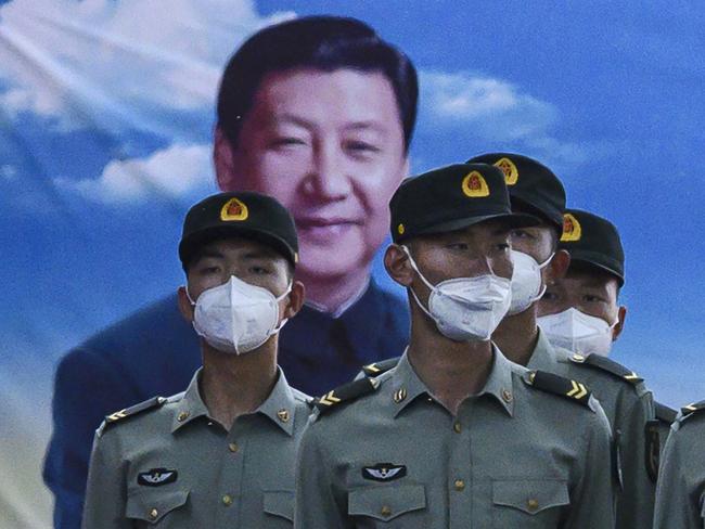 Soldiers of the People's Liberation Army's Honour Guard Battalion stand at attention in front of photo of China's president Xi Jinping. Picture: Getty Images