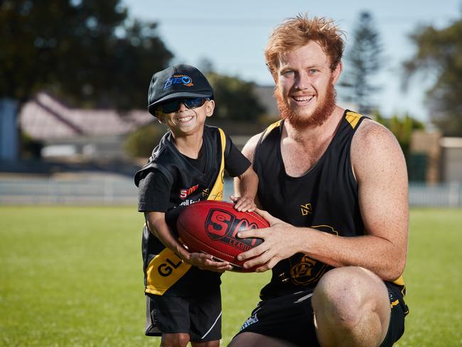 Glenelg Footballer, Josh Scott poses for a picture with Enzo Cornejo, 7 at Glenelg Football Club in Glenelg East, where Josh will shave his head to raise money to help Enzo travel to the USA for life-changing clinical trials, Tuesday, March 26, 2019. Picture: MATT LOXTON