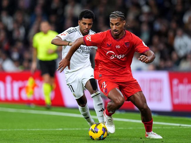 MADRID, SPAIN - DECEMBER 22: Loic Bade of Sevilla FC runs with the ball whilst under pressure from Rodrygo of Real Madrid during the LaLiga match between Real Madrid CF and Sevilla FC at Estadio Santiago Bernabeu on December 22, 2024 in Madrid, Spain. (Photo by Angel Martinez/Getty Images)