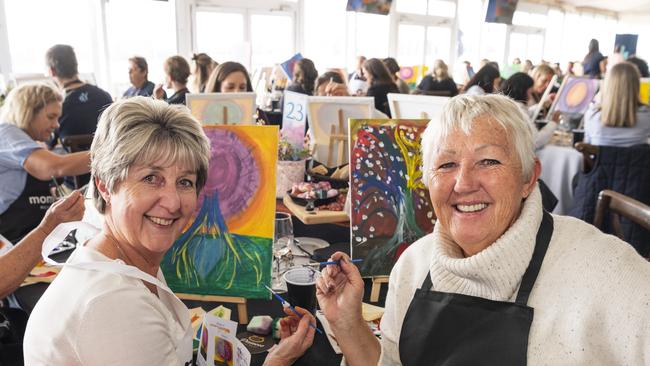 Aletta Barry (left) and Sian Rensford participating in the World's Largest Paint and Sip Luncheon for Momentum Mental Health at Clifford Park racecourse, Friday, June 21, 2024. Picture: Kevin Farmer