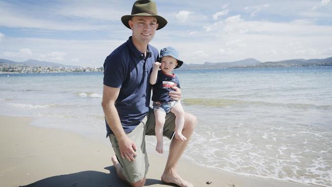 Richard Griggs has been petitioning to get the Derwent Estuary water quality improved. Mr Griggs is pictured at one of the worst affected sites, Nutgrove Beach, with his son, Tom, 1. Picture: MATHEW FARRELL