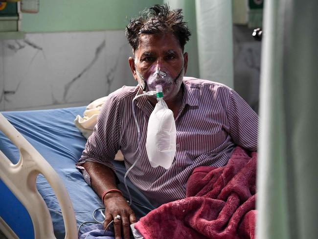 A COVID-19-positive patient uses an oxygen mask while in a hospital intensive care unit in India. Picture: Prakash Singh / AFP