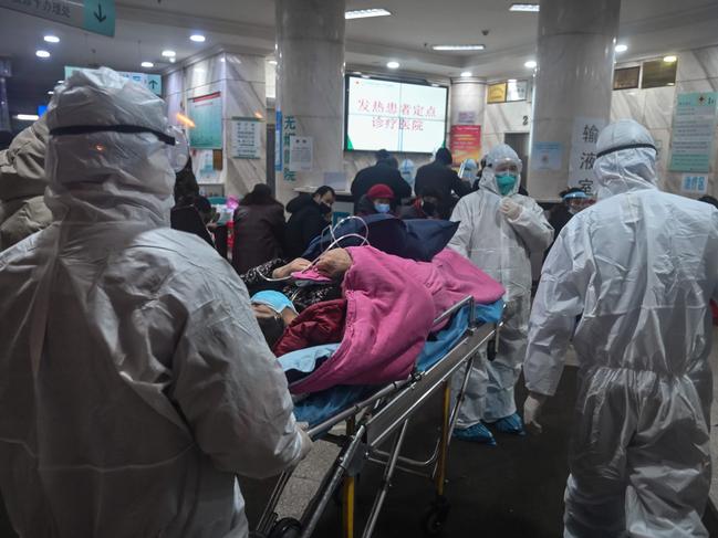 Medical staff wearing protective clothing to protect against a previously unknown coronavirus arrive with a patient at the Wuhan Red Cross Hospital in Wuhan. Picture: AFP