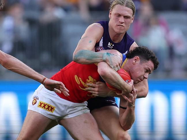 PERTH, AUSTRALIA - AUGUST 06: Hayden Young of the Dockers tackles Lachie Neale of the Lions during the round 21 AFL match between Fremantle Dockers and Brisbane Lions at Optus Stadium, on August 06, 2023, in Perth, Australia. (Photo by Paul Kane/Getty Images)