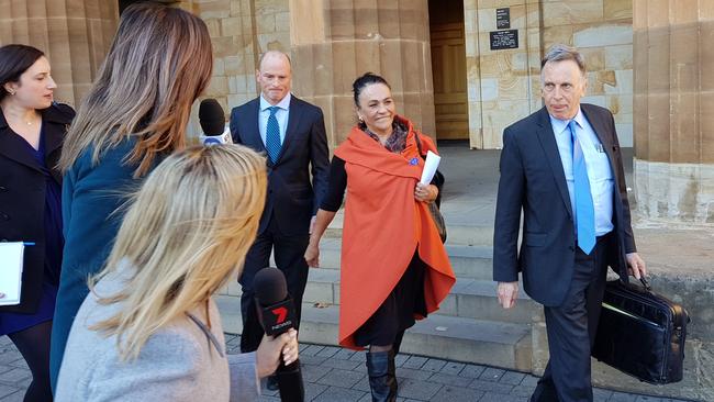 Yvonne Debra Buza, centre, leaves the Adelaide Magistrates Court after receiving a suspended sentence for fraud. Picture: Sean Fewster