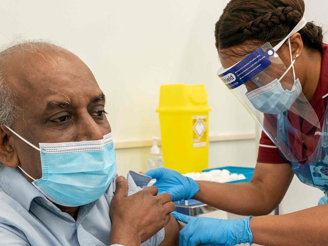 Care home worker Pillay Jagambrun (L), 61, reacts as he receives a dose of the Pfizer/BioNTech Covid-19 vaccine at Croydon University Hospital in south London on December 8, 2020. - Britain on December 8 hailed a turning point in the fight against the coronavirus pandemic, as it begins the biggest vaccination programme in the country's history with a new Covid-19 jab. (Photo by Dan CHARITY / POOL / AFP)