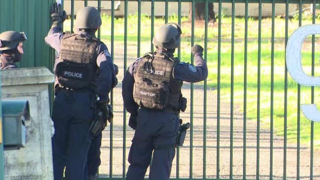 Police surround the clubhouse at Horsley Park before a man surrendered.