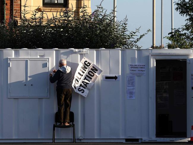 A man hangs a polling station sign on a mobile unit at a Lidl supermarket car park in Loughborough, central England, on July 4. Picture: AFP