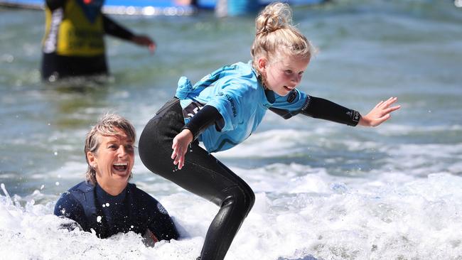 Layne Beachley with Bella Kay 9 of Hobart. Former world champion surfer Layne Beachley at the Women in Waves day at Clifton Beach. Picture: Nikki Davis-Jones.