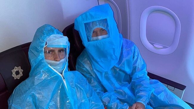 Cricketers Kane Williamson (left) and David Warner are seen in hazmat attire on a flight. Picture: Instagram @davidwarner31