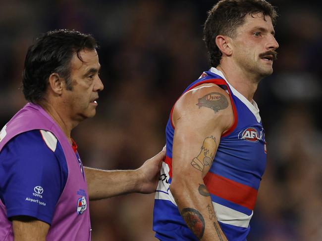 MELBOURNE , AUSTRALIA. April 12, 2024.  AFL. Round 5. Western Bulldogs vs Essendon at Marvel Stadium.   Bulldog Tom Liberatore in the hands of a trainer after being solidly tackled by Jake Stringer of the Bombers      . Pic: Michael Klein