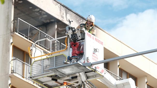 A firefighter at the end of a crane puts out the fire that broke out on the 11th floor of the Pacific Hotel on Sunday.