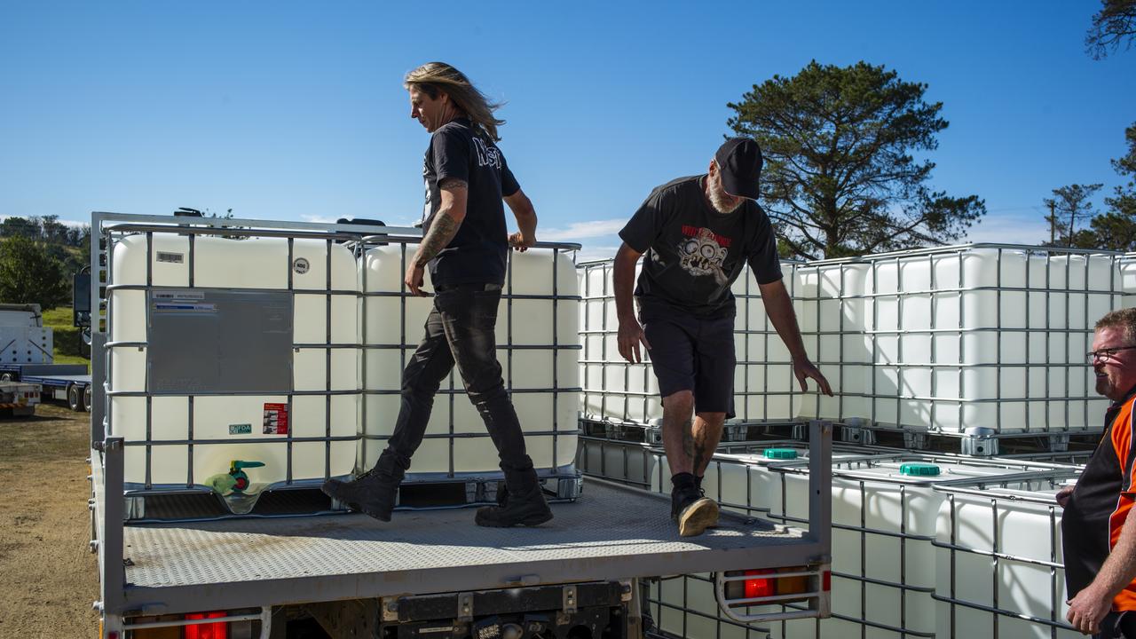 Locals Jamie Robinson (left) from Yowrie and John Burgess help to load donated water tanks. Picture” Sean Davey