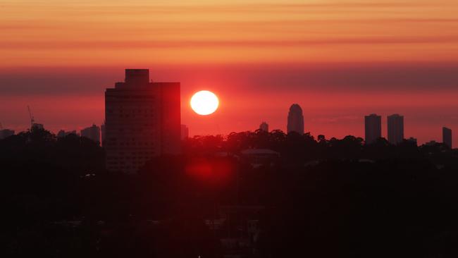 Maroon sky in the morning ,Blues warning.  A smoky haze over the Gold Coast made for a spectacular sunrise this morning with Royal pines in the foreground. Picture Glenn Hampson