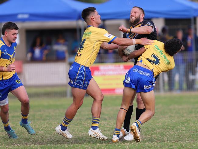 Coedi Towney charges at Darnell Walker (left) and Sean Trindall. Picture: Steve Montgomery/Ourfootyteam