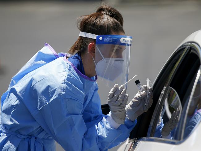 A health worker conducts an appointment-only coronavirus drive-thru COVID-19 swab test.